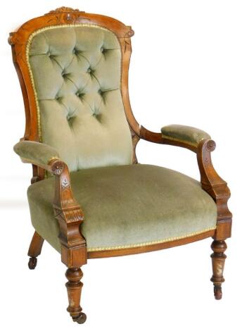 A Victorian walnut showframe open armchair, with a button padded back, padded arms and seat on turned tapering legs.