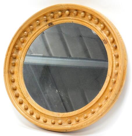 A 19thC pine circular wall mirror, with the moulded frame inset with spheres, 58cm diameter.