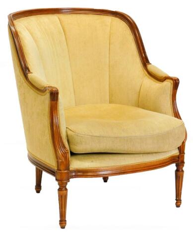 A continental walnut armchair, upholstered in gold coloured fabric, with moulded show frame and turned tapering legs. The upholstery in this lot does not comply with the 1988 (Fire & Fire Furnishing) Regulations, unless sold to a known exporter or upholst