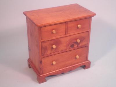 An early 20thC yew apprentice chest of two short and two long drawers on bracket feet