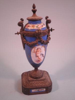 A late 19thC French gilt metal urn with porcelain mounts decorated with