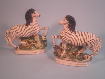 A pair of 19thC Staffordshire pottery flatback figures of zebra