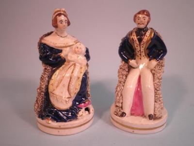 A pair of Victorian Staffordshire pottery figures each in the form of Queen