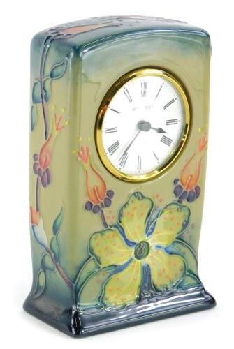 A Moorcroft pottery mantel timepiece, decorated with flowers, on a blue, beige ground, impressed marks to underside, 15cm high.