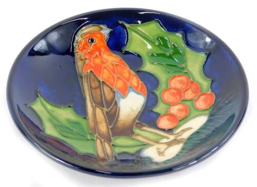 A Moorcroft pottery pin tray, decorated with a robin, holly and berries, impressed marks to underside, 12cm diameter.