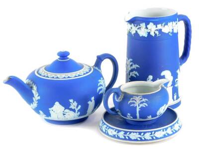 A collection of Wedgwood dark blue jasperware, to include a jug, teapot and cover, milk jug and a stand, (4).