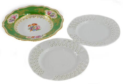 A 19thC English porcelain soup plate, painted with flower sprays, on a green ground with gilt borders, unmarked, 27cm diameter, and a pair of undecorated ribbon plates, blue cross swords marked to underside, 22.5cm diameter.