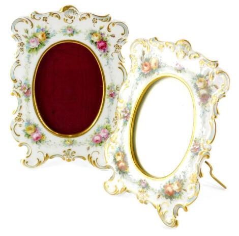 A pair of D & Co. Limoges porcelain photograph frames, each decorated with flowers, within rococo scroll gilt borders, printed marks to underside, 23cm high, 16cm wide.