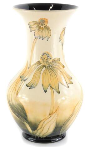 A Moorcroft pottery vase, decorated with yellow flowers on a cream ground, impressed marks to underside, 33cm high.