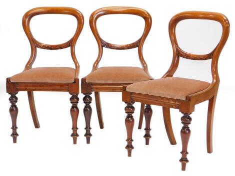 A set of three Victorian mahogany balloon back chairs, each with part leaf carved back, drop in seat on a turned tapering legs.