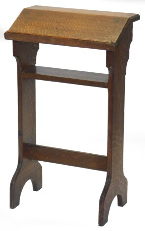 An oak prayer stand, with slope top, on end supports with shelf and stretcher, 82cm high, 47cm wide.