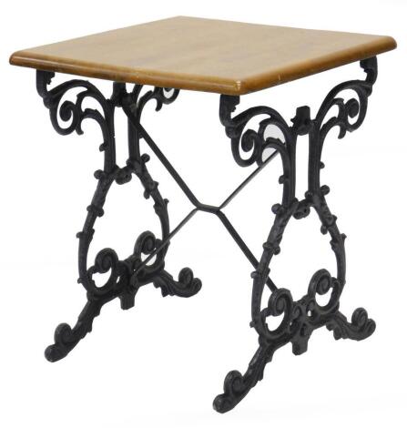 A cast iron pub table, the square hardwood top on end supports, 70cm high, 60cm wide.