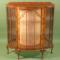 A walnut veneered bow fronted Art Deco style display cabinet