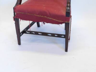 A George III mahogany open armchair, with a padded back, arm rest and seat, the shaped arm supports carved with bell flowers and patera, on square tapering legs with pierced H stretcher, 62cm wide overall. - 2