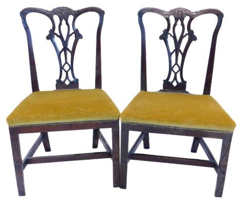 A pair of George III mahogany side chairs, in the manner of Thomas Chippendale, with a carved back, with a pierced vase shaped splat, with a padded seat on blind fret carved front legs on H stretcher.