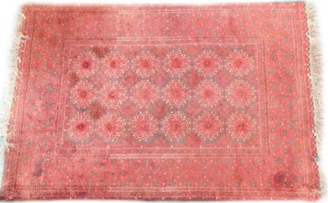 A Turkoman carpet, with a design of medallions, on a deep red ground with one wide and multiple borders, (AF), 298cm x 208cm.