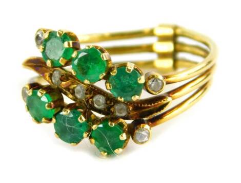 An emerald and diamond tri-band ring, the two outer bands set with design on three emeralds and four tiny CZ stones, the central weave design band set with four CZ stones, yellow metal stamped 14k, ring size L½, 3.3g all in.