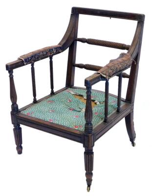 An early 19thC mahogany open armchair, the moulded frame with a double rope twist back, a padded seat on turned reeded legs, the arm with brass collar possibly for a reading stand. (AF)