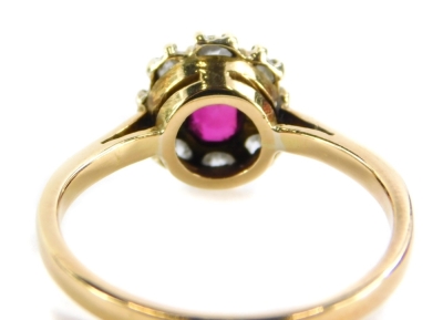 A ruby and diamond cluster ring, with over cut ruby in claw setting, surrounded by round brilliant cut diamonds, on a yellow metal band stamped 18ct, ring size R, 3.5g all in. - 2