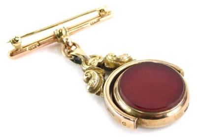 A late 19thC swivel agate fob, the earlier fob converted to a brooch with green and red agate, on a yellow metal scroll rococo setting, stamped 10ct, on a later 9ct gold pin bar, 5cm high x 4cm wide, 18.2g all in.