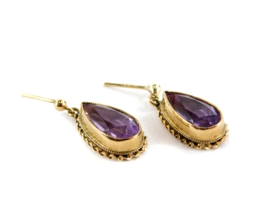 A pair of 9ct gold amethyst drop earrings, the teardrop cut amethyst in a raised setting with rope twist border, lacking backs, 1.5cm high, 3.8g all.