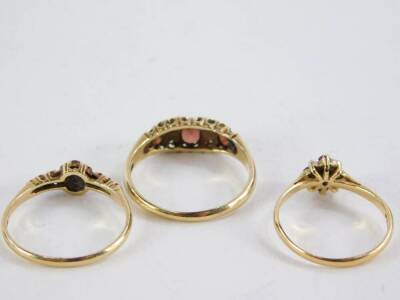 Three gold and red stone dress rings, two set in 9ct gold, 4.4g all in, and one set in 18ct gold, 1.9g all in. - 2