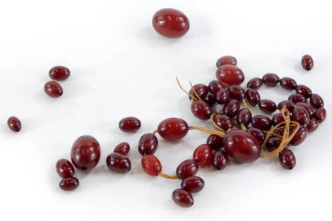 A string of dark red amber beads, the largest approximately 2.5cm wide, possibly incomplete.