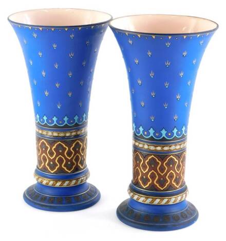 A pair of Mettlach vases, each with incised decoration in ecclesiastical Gothic style, in blue, black, gold and brown, impressed marks to underside, bearing number 1897, 26cm high.