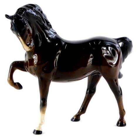 A Beswick brown glazed horse, with raised leg, 19cm high.