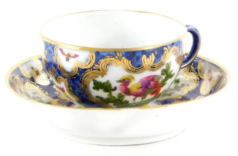 A Samson French porcelain cup and saucer, decorated in Worcester style with Asiatic pheasants and insects, within gilt cartouches on a blue scaled ground, pseudo Chinese mark to underside, the saucer 12cm diameter.