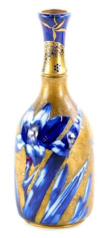 A Doulton ceramic bottle shaped vase, decorated with flowers in under glazed blue, with over decoration in gilt of further flowers in the aesthetic style, printed mark in black to underside, Victorian lozenge mark, etc., 17.5cm high.