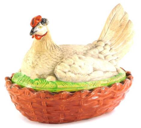 A 19thC Staffordshire porcelain hen shaped tureen, the lid moulded as a seated hen on a green base, the lower section with stylised basket weave, unmarked, (AF), 21cm long.