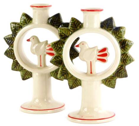 A pair of Lisa Larson design Swedish candlesticks, each moulded with a central bird around a roundel, applied with leaves on a tapering base, Hoganas Keramik Stoneware mark to underside, 20.5cm high.