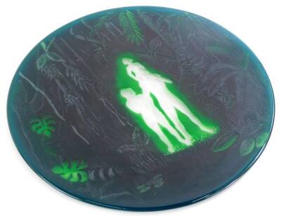 A green acid etched and engraved plaque, depicting a male, female and a child in a jungle setting, in the manner of Webb, unmarked, 27cm diameter.