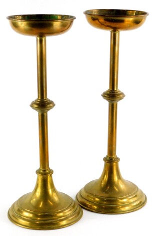 A pair of ecclesiastical brass candlesticks, each with a domed sconce and foot, 48cm high.