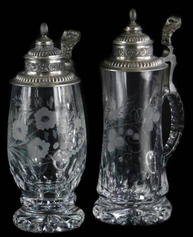 Two matching cut glass and engraved glass beer steins, each with a pewter lid, 25cm and 27cm high.