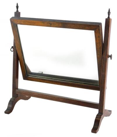 A mahogany swing frame dressing table mirror, the rectangular plate on reeded supports, headed by turned brass finials, 37cm wide.