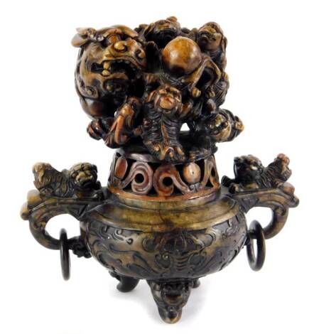 An oriental stained soapstone Koro, decorated with a dragon, the base with two ring handles, etc.