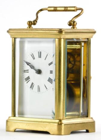 A French brass carriage clock, with a loop handle, the white enamel dial with Roman numerals, 14cm high overall.