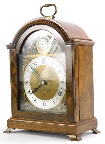 An Elliott mantel clock, in a walnut case, the arched dial stamped Tempus Fugit Made In England, 25cm high.