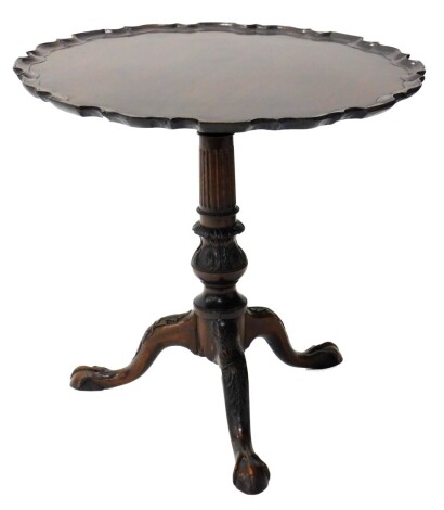 A mahogany occasional table in George III style, the circular pie crust top, on a reeded leaf carved column and tripod base with ball and claw feet, 54cm high, 59cm diameter.