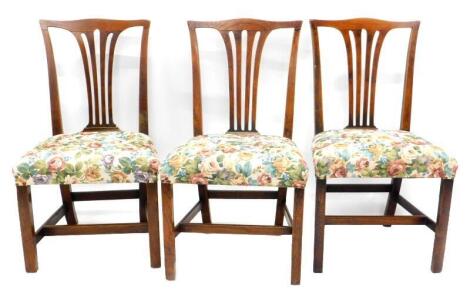 A set of three early 19thC oak dining chairs, each with a pierced vase shaped splat, a padded seat, on square section legs with H stretcher.