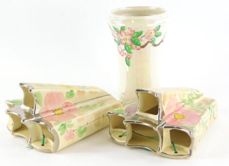 A pair of Arthur Wood Art Deco wall pockets, each decorated with flowers, a Maling lustre vase with raised decoration of flowers. (3)