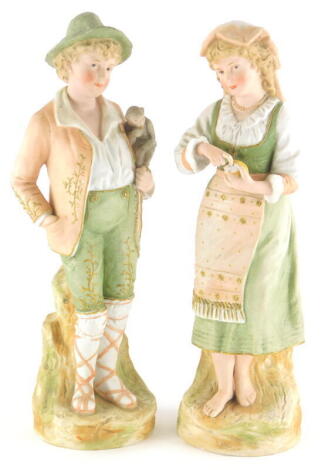 A pair of unusual late 19thC German bisque figures, each modelled as a gentleman in Bavarian costume with a monkey and accompanying lady with fruit, 38cm high.