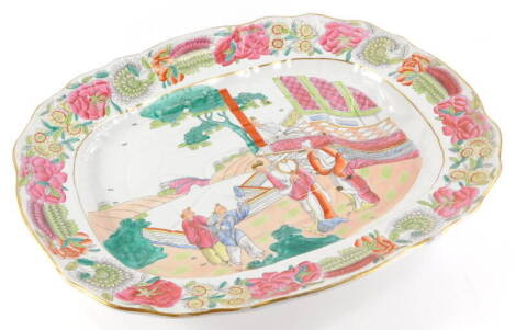 A 19thC Staffordshire meat dish, printed and painted with oriental scenes, within a floral border, blue cross swords mark to underside and pattern number 2823, 55cm wide.