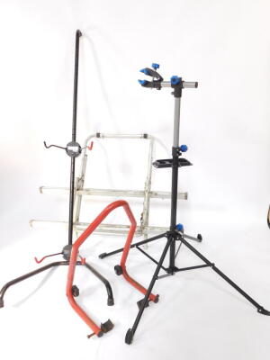 A Crivit Sports bicycle repair stand, FN-1290., a bike tree, and a bike rack. (3)