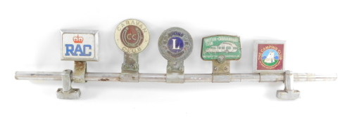 A car badge bar holding five badges, for RAC., Caravan Club., Lion's International., British Caravanner's Club., and The Camping Club.