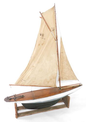 A wooden scale model of a single masted yacht, fully rigged, on a stand, 138cm wide.