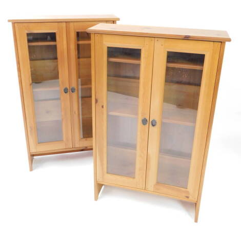 A pair of pine display cabinets, for model soldiers, each with two glazed doors, opening to reveal five shelves, 112cm high, 69.5cm wide, 21cm deep.