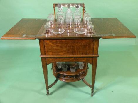 An Edwardian oak metamorphic drinks cabinet